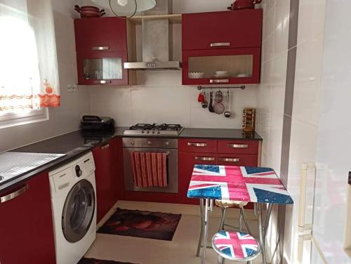 una cucina con armadi rossi e una lavatrice di La crique a Alger