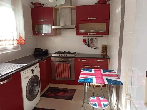 阿爾及爾的住宿－La crique，一间带红色橱柜和洗衣机的厨房