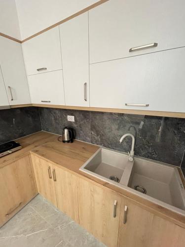 a kitchen with white cabinets and a sink at Villa Soni Oruci in Ksamil