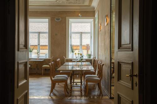 a dining room with a table and chairs and windows at Unfound Door - Design Hotel in Tbilisi City