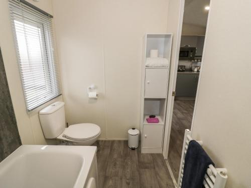 a white bathroom with a toilet and a sink at Carolina Lodge in Evesham