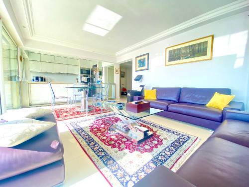 a living room with a purple couch and a glass table at Antinéa By SCLS Locations in Cannes