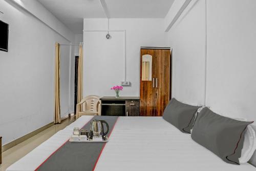 a white room with a bed with a table at Hotel O Homely Stay in Aurangabad