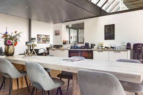 a large dining room with a large table and chairs at Rue Haute by M&M 4 sterren bed en breakfast vlakbij Maastricht in Eben-Emael