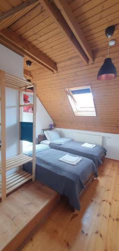 1 dormitorio con 2 camas en una habitación de madera en Buborék Apartman - Etyek en Etyek