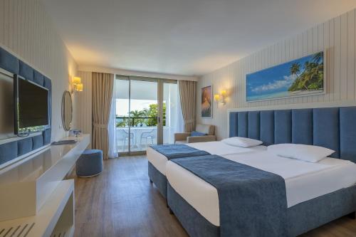 Habitación de hotel con cama y TV en MIRADA DEL MAR HOTEL, en Antalya