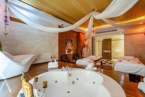 uma grande casa de banho com banheira e 2 camas em MIRADA DEL MAR HOTEL em Antalya