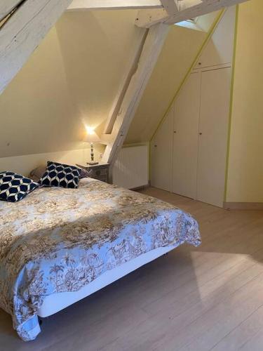 a bedroom with a large bed in a attic at Propriété à 3 mins du Château du Haras du Pin in Le Pin-au-Haras