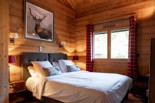 a bedroom with a bed in a log cabin at Chalet de l'Atray in Les Gets