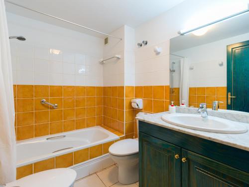 a bathroom with a tub and a toilet and a sink at Las Moreras Playa Blanca in Playa Blanca