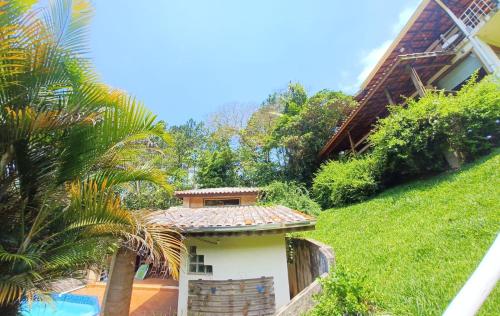 a house with a swimming pool and a palm tree at Chalé Serra Cantareira in Mairiporã