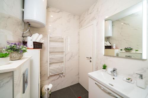 een witte badkamer met een wastafel en een spiegel bij Guesthouse Slavka in Dubrovnik