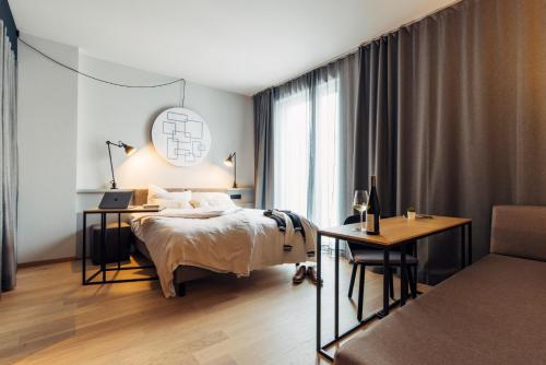 een slaapkamer met een bed en een bureau met een laptop bij harry's home Zürich-Limmattal in Spreitenbach