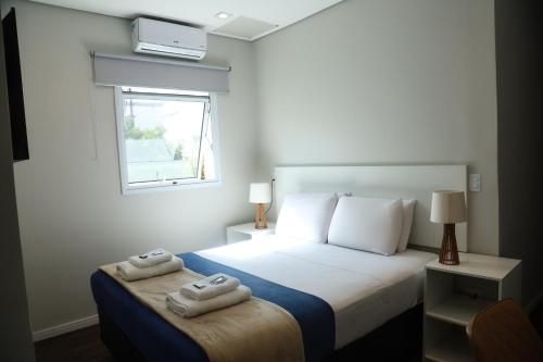 a bedroom with a bed with two towels on it at GoodStay São Paulo Ibirapuera in Sao Paulo