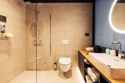 a bathroom with a shower and a toilet and a sink at harry's home Zürich-Limmattal in Spreitenbach