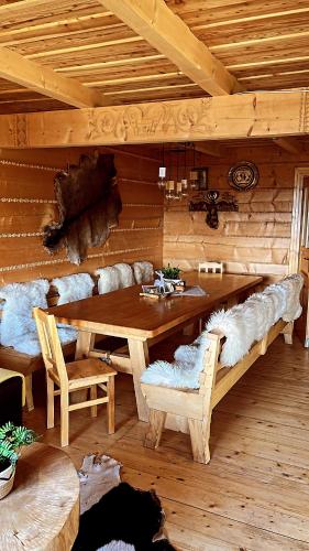 a wooden room with a wooden table and benches at Domek w Górach- Bacówka u Dudka in Nowy Targ