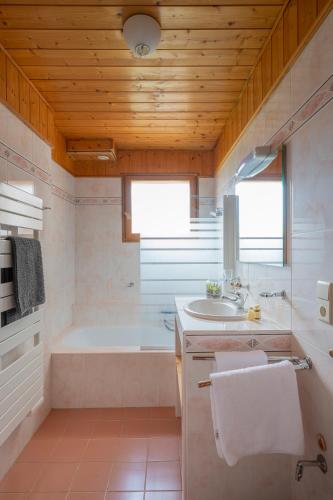 une salle de bain avec une baignoire et un lavabo dans l'établissement Chalet Au Gré Du Temps, aux Gets