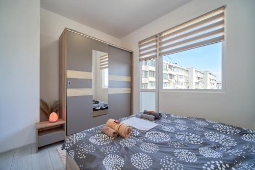 a bedroom with a bed and a large window at Cozy Apartment with Balcony on the Black Sea- part of the family 'Vicki Apart in Varna City