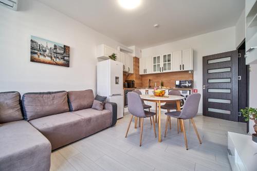 a living room with a couch and a table with chairs at Cozy Apartment with Balcony on the Black Sea- part of the family 'Vicki Apart in Varna City