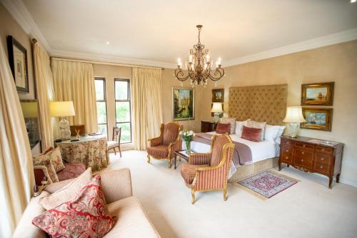 - une grande chambre avec un lit et un lustre dans l'établissement Kilima Franschhoek, à Franschhoek
