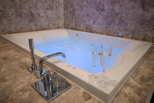 a bath tub with two wine glasses in it at Hawkshead Suites in Hawkshead