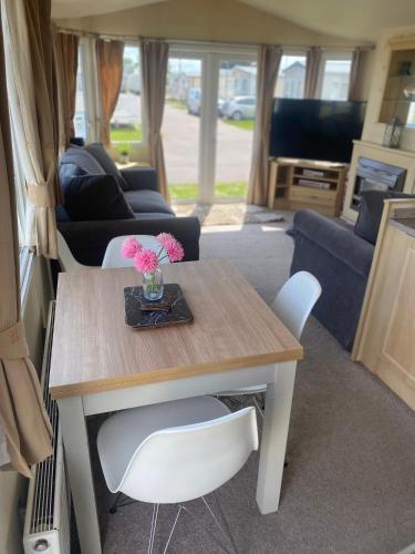 een woonkamer met een tafel en stoelen in een camper bij 6 berth Seawick Caravan Park, St Osyth in Colchester