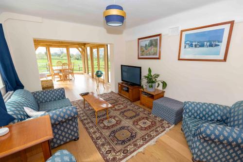 a living room with two couches and a television at Hayes Farm - 8 Houses in Gloucester