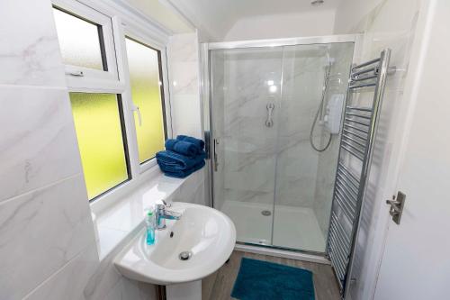 a white bathroom with a shower and a sink at Hayes Farm - 8 Houses in Gloucester