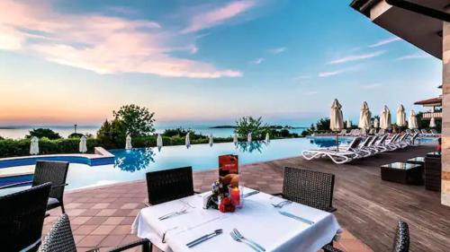 a view of a pool at a resort with a table and chairs at Santa Marina Holiday Village Studio Iskra in Sozopol