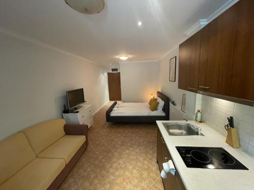 a living room with a couch and a bed in a room at Santa Marina Holiday Village Studio Iskra in Sozopol