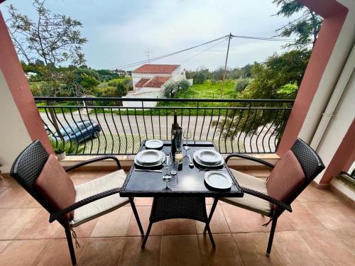 una mesa y sillas en un balcón con vistas en Casa Ana at Opomar by Cara Rentals, en Tavira