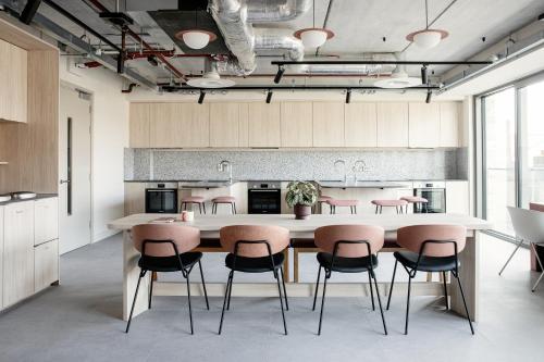 a kitchen with a large table with pink chairs at Niche Living - Dun Laoghaire in Dublin