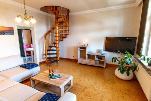 un soggiorno con scala a chiocciola e TV di Villa Bertha a Ostseebad Sellin