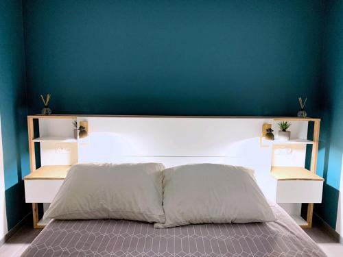 un letto in una camera da letto con parete blu di Eco-Appart'hôtel Rouen -- JDP a Rouen