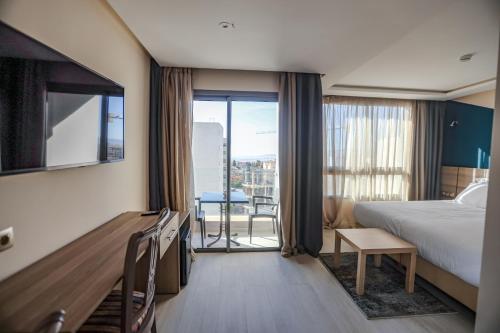 um quarto de hotel com uma cama e uma varanda em HOTEL BELLE VUE MEKNES em Meknès
