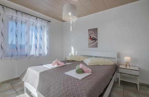 a bedroom with a bed with pink pillows on it at Holiday house NIKA with pool and jacuzzi in Linardići