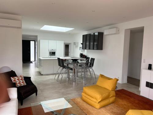 Il comprend un salon et une cuisine avec une table et des chaises. dans l'établissement MAISON TOUSVENTS, à Saint-Georges-de-Didonne