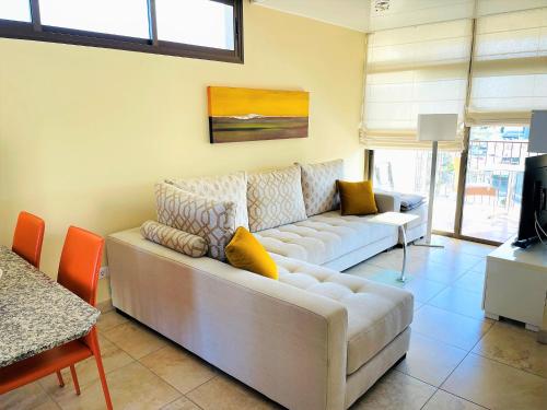 ein Wohnzimmer mit einem weißen Sofa und einem TV in der Unterkunft Apartment Mananem in Playa del Ingles
