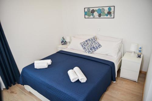 - une chambre avec un lit bleu et des serviettes dans l'établissement Locus Apartments, à Petrčane