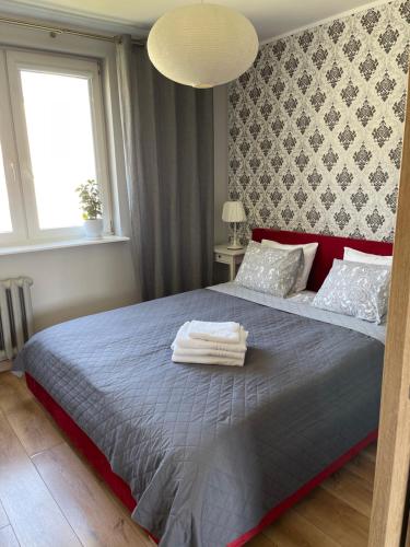 a bedroom with a bed with two towels on it at Apartament Centrum in Lidzbark Warmiński