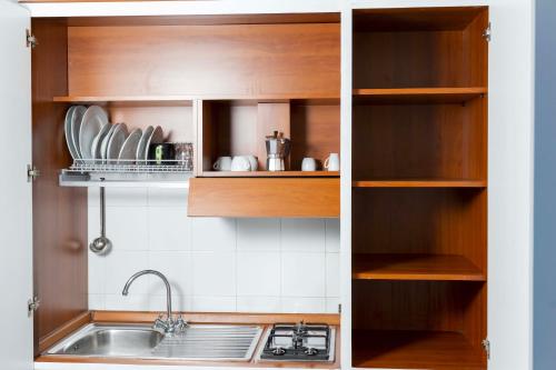a kitchen with wooden cabinets and a sink at Cala Moresca Apartments in Bacoli
