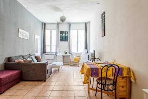 un salon avec un canapé et une table dans l'établissement Appartement Blacha - Welkeys, à La Ciotat