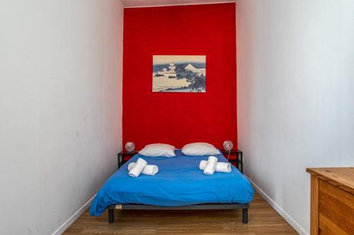 - une chambre avec un lit bleu et un mur rouge dans l'établissement Appartement Blacha - Welkeys, à La Ciotat