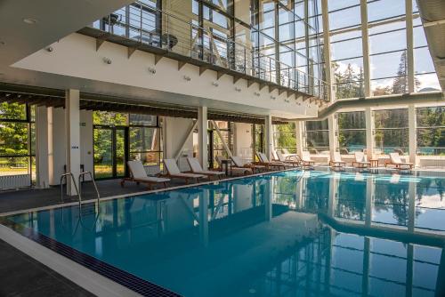 a large swimming pool with chairs and windows at Euphoria Club Hotel in Borovets