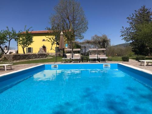 - une piscine avec 2 chaises et une maison dans l'établissement La Casa Lemuria - Süd-Toscana, à Zancona