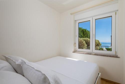 una camera con letto e finestra di Pool Apartment Maurina Opatija with sea view a Ičići