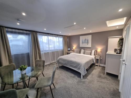 a bedroom with a bed and a table and chairs at The Boathouse in Lee-on-the-Solent