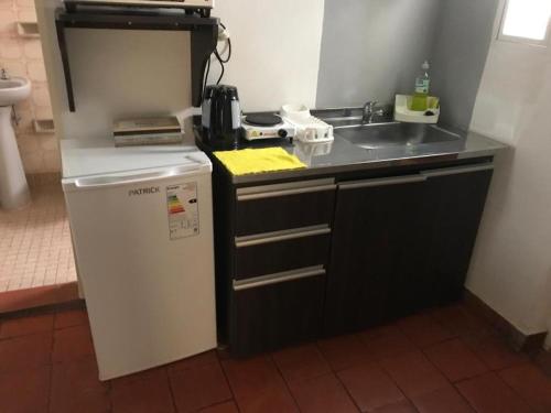a small kitchen with a sink and a refrigerator at Dpto cerca del Centro y de la Costanera in Corrientes