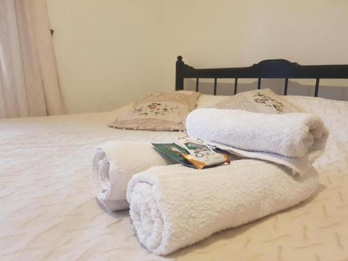 uma cama com toalhas brancas e livros em Dpto cerca del Centro y de la Costanera em Corrientes