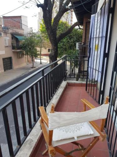 a wooden bench sitting on a balcony with a tree at Dpto cerca del Centro y de la Costanera in Corrientes